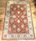 A Zeigler style hand knotted rug, the faded red field with interlaced foliate and lotus head