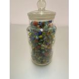 A large clear glass sweetie jar containing a large collection of marbles, (jar h 25cm x 13cm)