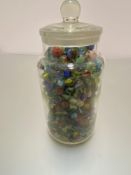 A large clear glass sweetie jar containing a large collection of marbles, (jar h 25cm x 13cm)