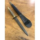 A Reproduction of a Fairburn Sykes Fighting knife, the brass handle stamped with broad arrow, in