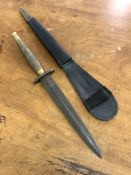 A Reproduction of a Fairburn Sykes Fighting knife, the brass handle stamped with broad arrow, in