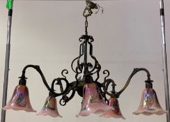 A Bronzed cast and wrought metal electrolier, with five branches, polychrome glass shades, chain and