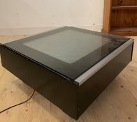 A contemporary coffee table of square form, the plate glass top enclosing colour changing fibre