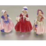 A collection of three Royal Doulton china figures, Dinky Do, HN1678FB, Babie HN1678HF, and Lavinia