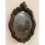 A large early 20th century wall clock, the glazed mahogany case of cartouche form with lion mask and