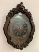 A large early 20th century wall clock, the glazed mahogany case of cartouche form with lion mask and