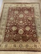 A hand knotted Persian Ziegler design rug, the red field with floral decoration enclosed by an ivory