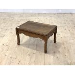 An early 20th century Chinese rosewood low table, with panelled top, shaped frieze and turned