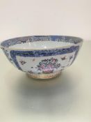 An 18thc Chinese porcelain punch bowl decorated with famille rose style floral sprays enclosed