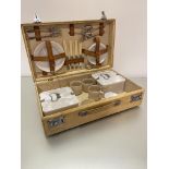 A 1930's pig skin picnic case complete with early plastic cups, saucers, side plates, sandwich