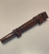 A Balinese tropical hardwood carved mask woodwind instrument, with six various holes to front of