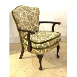 A George III style mahogany elbow chair, the upholstered shield back over scrolled open arms and