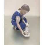 A Bing and Grondahl Danish porcelain figure of a young girl feeding her cat, decorated with