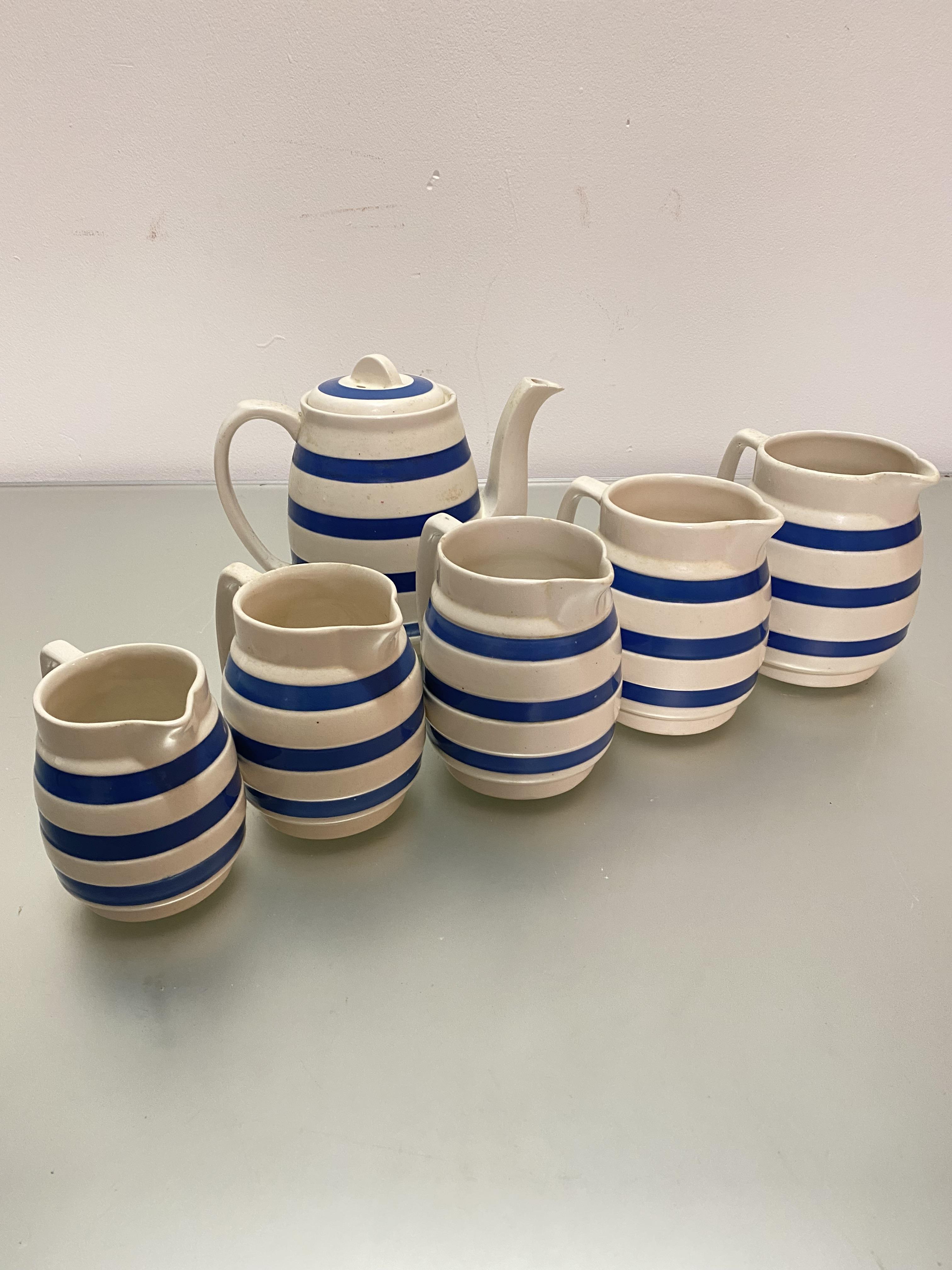 A set of five graduated Chefware Staffordshire blue and white striped jugs and matching teapot, (