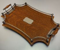 An Edwardian oak two-handled tea tray with Epns gallery with presentation plaque presented to Miss