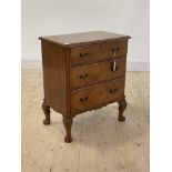 An early 20th century hardwood chest, the hinged top over three graduated drawers with quarter