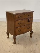 An early 20th century hardwood chest, the hinged top over three graduated drawers with quarter