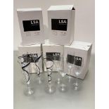 Three boxes of four clear LSA champagne flutes and two boxes of Black Jazz champagne flutes, each