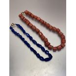 A pink coral stem necklace with yellow metal clasp fastening, (L 23cm) and a Lapis polished bead
