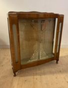 An Art Deco period walnut vennered display cabinet, with sliding glass doors enclosing two