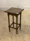 An early 20th century oak lamp table, the square top raised on bobbin turned and block supports,