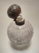 A crystal perfume bottle complete with Birmingham silver mounted hinged top, decorated with leaf and