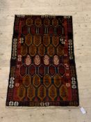 A New Baluchi rug, the red field with repeating lozenge motif, 90cm x 140cm