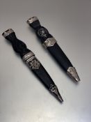 A pair of reproduction white metal faux ebony handled Sgian Dubh with white metal mounts and thistle