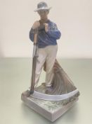 A Royal Copenhagen Danish porcelain figure of a farmer with his scythe, decorated with polychrome