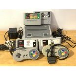 A Super Nintendo gaming system, with two controllers, four cartridges and power lead