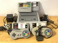 A Super Nintendo gaming system, with two controllers, four cartridges and power lead