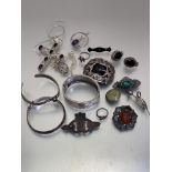 A collection of silver and white metal jewellery including an Edwardian engraved stiff hinged