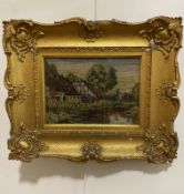 A wool work panel depicting cottages by stream, in gilt composition frame a/f, (19cm x 26cm)