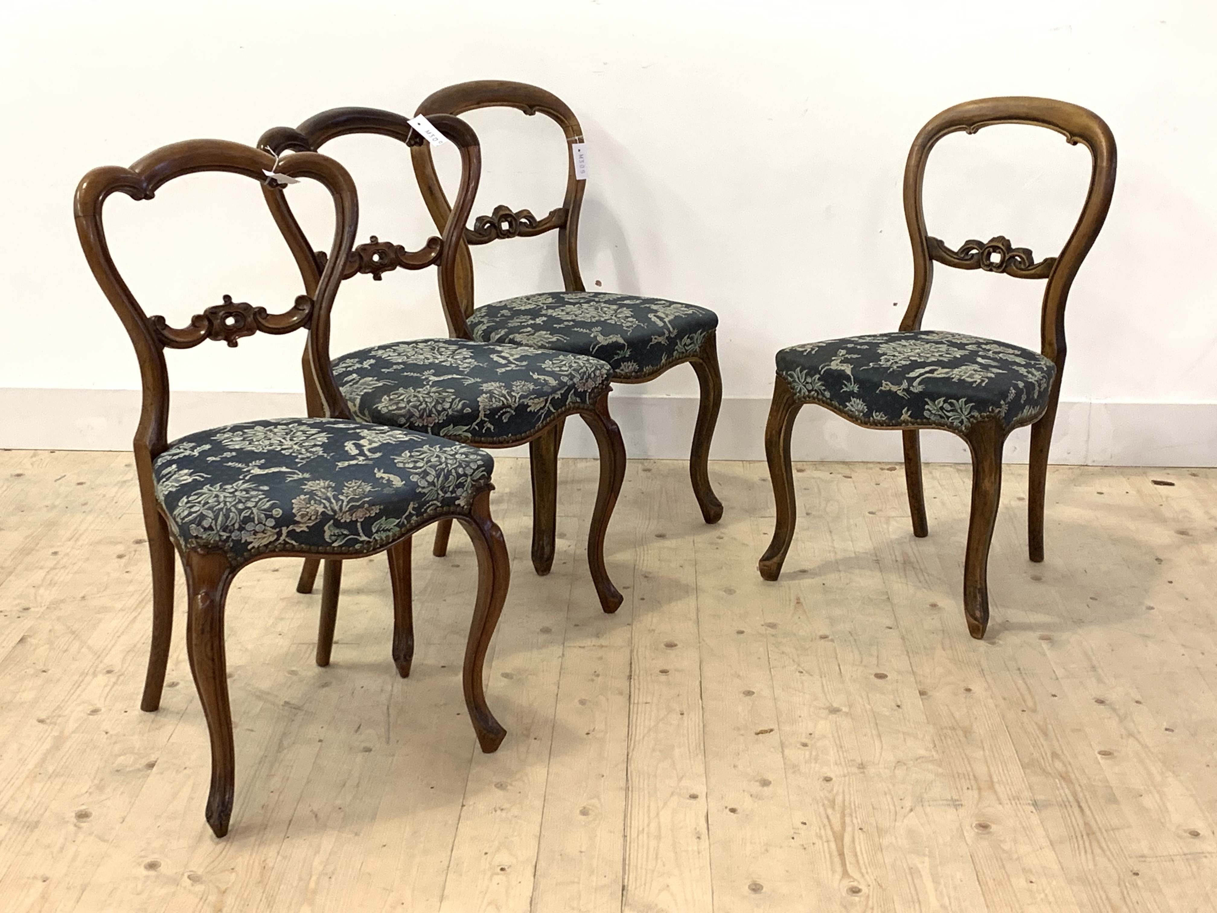 A harlequin set of four Victorian balloon back dining chairs, one pair in rosewood and the other