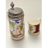 A Faience pottery tankard with pewter mount depicting figure playing flute within garden,