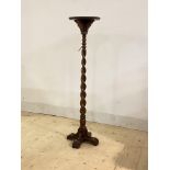 An early 20th century oak torchere, the circular top over spiral turned column and cruciform base,