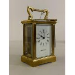 A gilt and lacquered brass carriage time piece clock, the case of typical design with swing carry