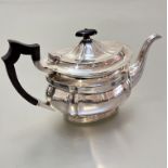 A Sheffield silver panelled teapot of oval form, raised on oval fluted base, (h15cm x 28cm including