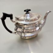 A Sheffield silver panelled teapot of oval form, raised on oval fluted base, (h15cm x 28cm including