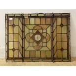 A late 19th/ early 20th century stained and leaded glass panel centred with a stylised floral