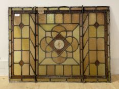 A late 19th/ early 20th century stained and leaded glass panel centred with a stylised floral