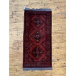 A small hand knotted Afghani runner rug, 114cm x 53cm