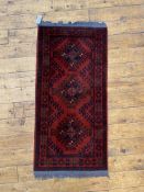 A small hand knotted Afghani runner rug, 114cm x 53cm