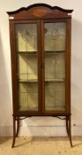 An Edwardian Art Nouveau style inlaid mahogany display cabinet, two lead glazed doors enclosing