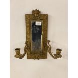 A late 19th century gilt brass mirrored wall sconce in the Neoclassical taste, with mask surmount