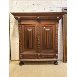 A 20th century Continental oak schrank cupboard, in the baroque style, the projecting cornice over