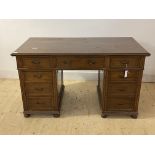 An Edwardian mahogany twin pedestal writing desk, the top with moulded edge over two slides, one