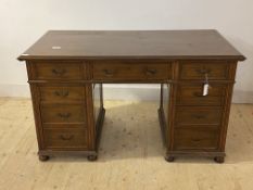 An Edwardian mahogany twin pedestal writing desk, the top with moulded edge over two slides, one