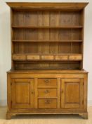 A pine dresser, early 19th century, the three height plate rack with five spice drawers, over base