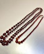 A dark amber graduated 1900/1920's bead necklaces, (L 38cm and 42cm) and a dark honey coloured bead